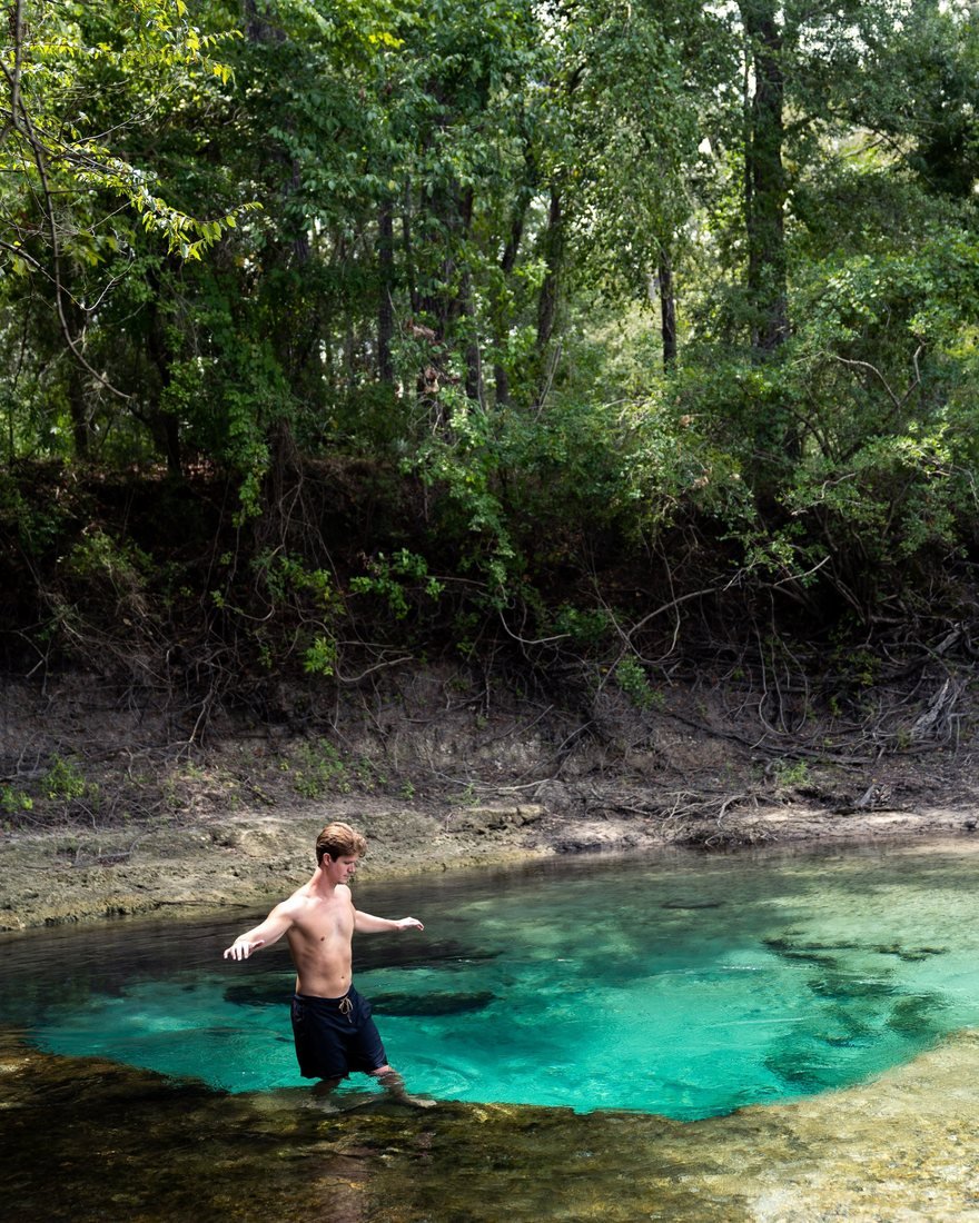 Brandon wading into a turquoise Florida spring
